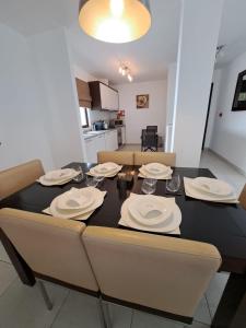 a dining room table with plates and napkins on it at Spacious family friendly 3-Bed Villa Dunas Resort in Santa Maria