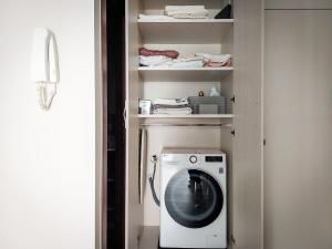 a laundry room with a washing machine in a closet at Villa Citrus in Riva del Garda