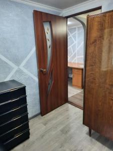 una puerta de madera en una habitación con espejo en Small Home, en Chişinău