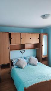 a bedroom with a large bed with wooden cabinets at Apartments Anić in Novigrad Istria