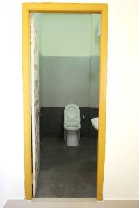 een badkamer met een wit toilet in een kamer bij Green Mango Farmhouse in Chityāl