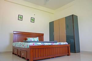 een slaapkamer met een houten bed en een spiegel bij Green Mango Farmhouse in Chityāl