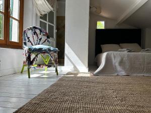 1 dormitorio con silla y 1 cama en Mymoustiers, en Moustiers-Sainte-Marie