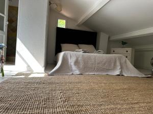 Un dormitorio con una cama con una manta blanca. en Mymoustiers, en Moustiers-Sainte-Marie