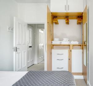 倫敦的住宿－Lovely Spot by City of London，一间卧室配有一张床,厨房配有白色橱柜