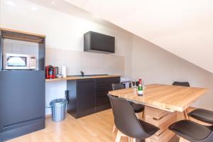 eine Küche und ein Esszimmer mit einem Holztisch und Stühlen in der Unterkunft 4k TV, Soundbar, Ausblick in Bad Dürrenberg