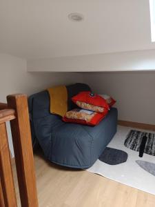eine blaue Couch mit Kissen darauf in einem Zimmer in der Unterkunft jolie maison neuve - malisone - in Pont-Sainte-Maxence