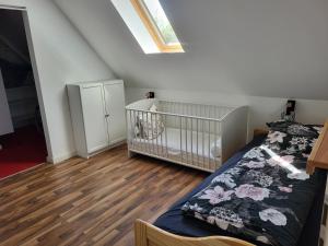 a bedroom with a crib and a wooden floor at Komplette 4 Zimmer OG Wohnung in Langwedel