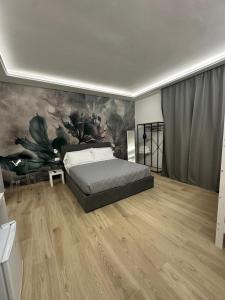 a bedroom with a bed and a painting on the wall at Maison Number11 in Caserta