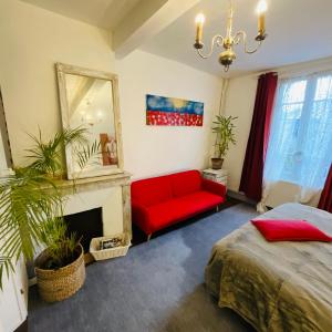 a living room with a red couch and a mirror at Mirepoix Labyrinthe chambre avec salle de bain et lit 180 cm in Mirepoix