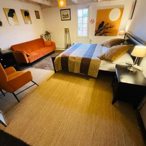 a bedroom with a bed and a couch at Mirepoix Labyrinthe chambre avec salle de bain et lit 180 cm in Mirepoix