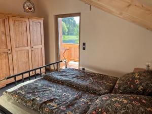 a bedroom with a bed and a large window at Mountain Hideout Wolfsee in Fischbachau