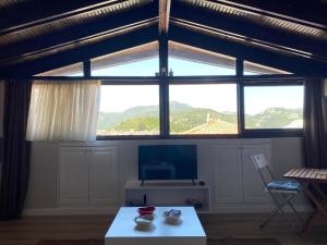 a living room with a large window and a table at Antik Apartments Marmaris in Marmaris