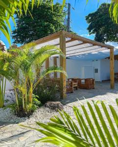 una pérgola de madera en un patio con algunas plantas en HUMMINGBIRD CABARETE en Cabarete