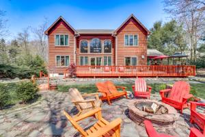 a house with chairs and a fire pit in front of it at Fire Pit and BBQ Elegant Split Rock Resort Getaway! in Lake Harmony
