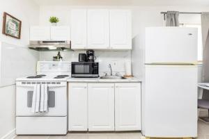 a kitchen with white appliances and a white refrigerator at Pet-Friendly Studio Unit in Chinatown in Ottawa