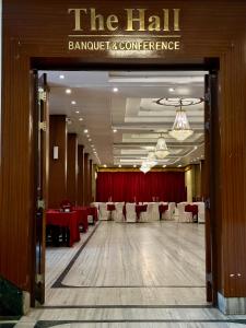 une salle de banquet avec des tables rouges et des chaises blanches dans l'établissement HOTEL RENDEZVOUS, à Gangtok