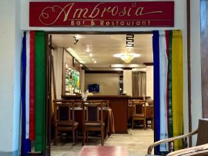 HOTEL RENDEZVOUS في جانجتوك: مطعم به طاولات وكراسي وعلامة ملونة