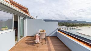 a balcony with a table and a view of the water at Albergaria Quim Barreiros in Vila Praia de Âncora