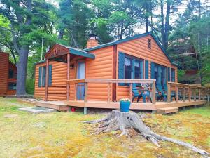 a large wooden cabin with a porch and a deck at Knotty Pine Norway Lake Minocqua in Minocqua