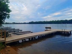 a dock with a bench sitting on top of a lake at Knotty Pine Norway Lake Minocqua in Minocqua