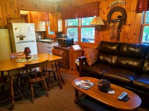 a living room with a leather couch and a table at Knotty Pine Norway Lake Minocqua in Minocqua