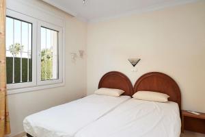 une chambre avec un lit avec des draps blancs et une fenêtre dans l'établissement Villa Amapola by ON Travel, à Oliva