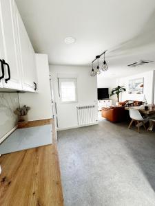 cocina y sala de estar con armarios blancos y mesa en Moderno Piso en Puerto Sagunto, en Puerto Sagunto