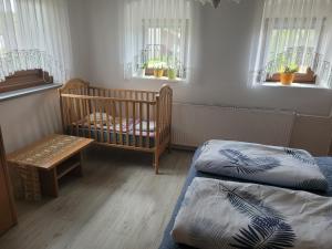 - une chambre avec 2 lits, un lit bébé et des fenêtres dans l'établissement Apartma Vida, à Videm pri Ptuju