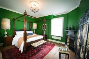 - une chambre avec des murs verts, un lit et un lustre dans l'établissement Ardrhu House Fort William - Serviced Luxury Scots Baronial Country House, à Fort William