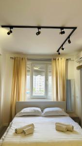 ein Schlafzimmer mit einem großen Bett mit zwei Handtüchern darauf in der Unterkunft Studio Apartment 24/7 Self Check-in in Tirana