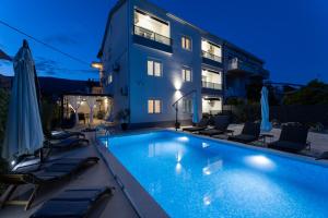 a swimming pool in front of a building at Moderni studio in Kaštela