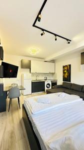 ein großes weißes Bett in einem Zimmer mit Küche in der Unterkunft Studio Apartment 24/7 Self Check-in in Tirana