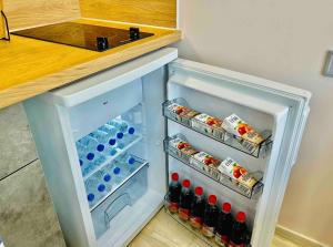 un réfrigérateur ouvert rempli de nourriture et de boissons dans l'établissement Port Twins Suites No2, au Pirée