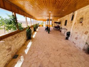 a large room with a stone floor and windows at Petra Royal Ranch in Wadi Musa