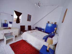 Schlafzimmer mit einem Bett, einem Schreibtisch und einem Spiegel in der Unterkunft Traditional Maltese townhouse in Rabat in Rabat