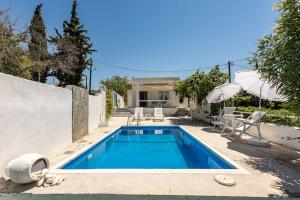 a swimming pool in front of a house at Villa Maria in Néa Michanióna