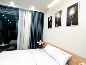 a bedroom with a white bed and some pictures on the wall at Sam's homestay- Swan lake studio apartment in Kim Quan
