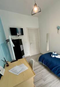 Schlafzimmer mit einem Schreibtisch, einem Bett und einem Tisch in der Unterkunft Rosaria's Home in Brindisi