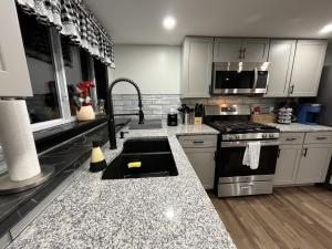 a kitchen with white cabinets and a stove top oven at Berkshires Studio Apartment at the Stephentown Hotel in Hancock