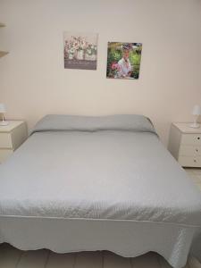uma cama num quarto com duas fotografias na parede em gaia em Terracina