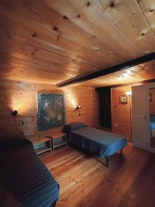 Habitación con 2 camas y TV en una cabaña en La Casa del Busso, en Boccioleto