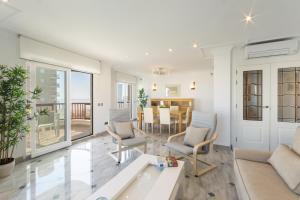 ein Wohnzimmer mit Sofa, Stühlen und einem Tisch in der Unterkunft AG Salinas 9 in Playa de Gandia