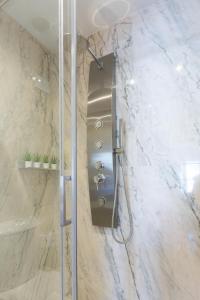 eine Duschkabine in einem Badezimmer mit Marmorwänden in der Unterkunft AG Salinas 9 in Playa de Gandia