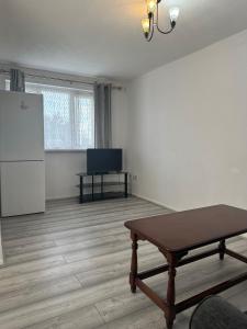 an empty room with a table and a refrigerator at Stunning one bed Apartment with free Wifi and Parking in Goodmayes