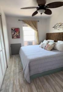 a bedroom with a bed with a ceiling fan at Salty Bones, Hemingway-esque Florida Escape, Boat On Property in Matlacha