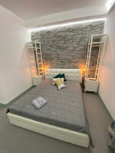 a bed in a room with a brick wall at Alice's Studio in Santa Marinella