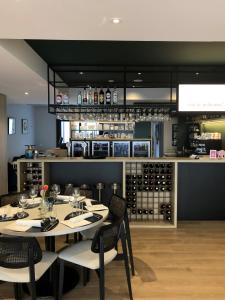een eetkamer met een tafel en stoelen en een bar bij HOTEL LEHOUCK in Koksijde