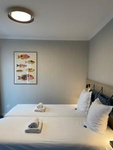 een slaapkamer met een bed met twee handdoeken erop bij HOTEL LEHOUCK in Koksijde