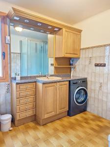 a bathroom with a washing machine and a sink at Appartement de montagne à La LLagonne in La Llagonne